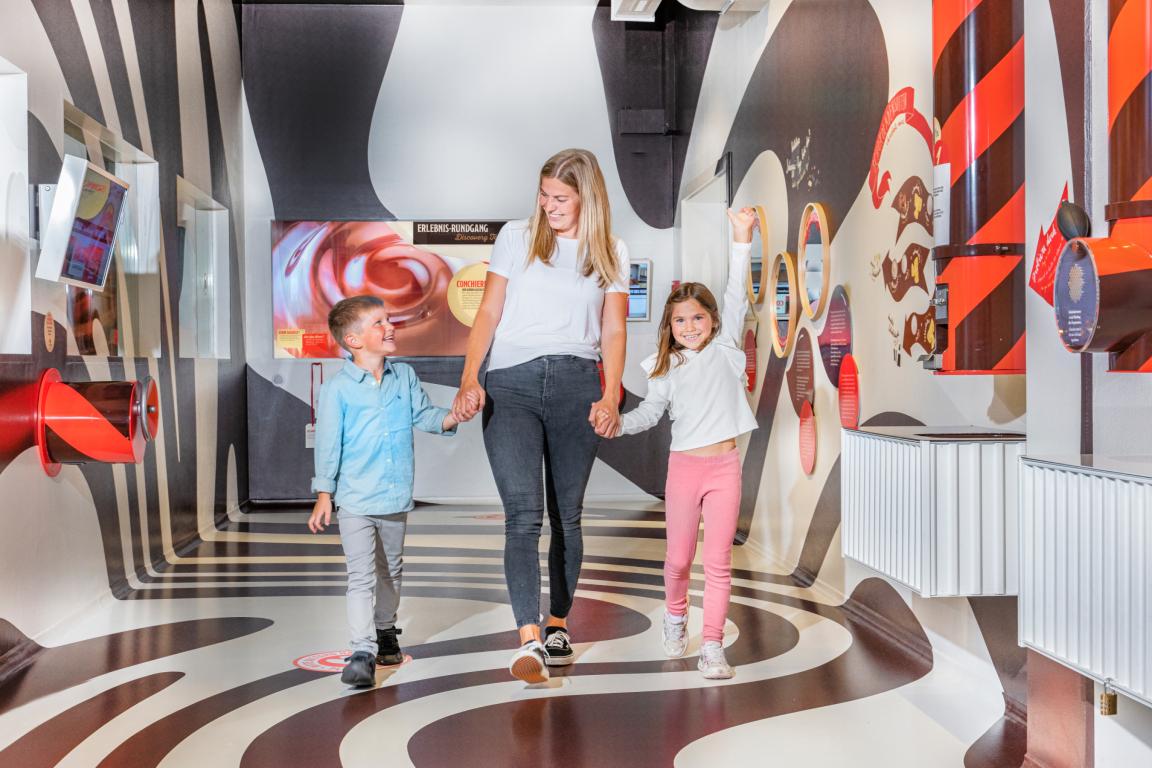 Mutter und zwei Kinder im Chocolarium. Verspielte Umgebung
